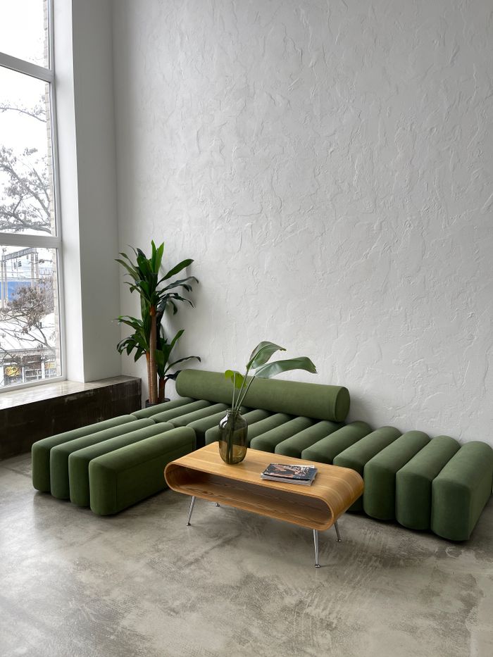 about-img Stylish modern interior with a green sofa and a wooden table by a large window in Kyiv.